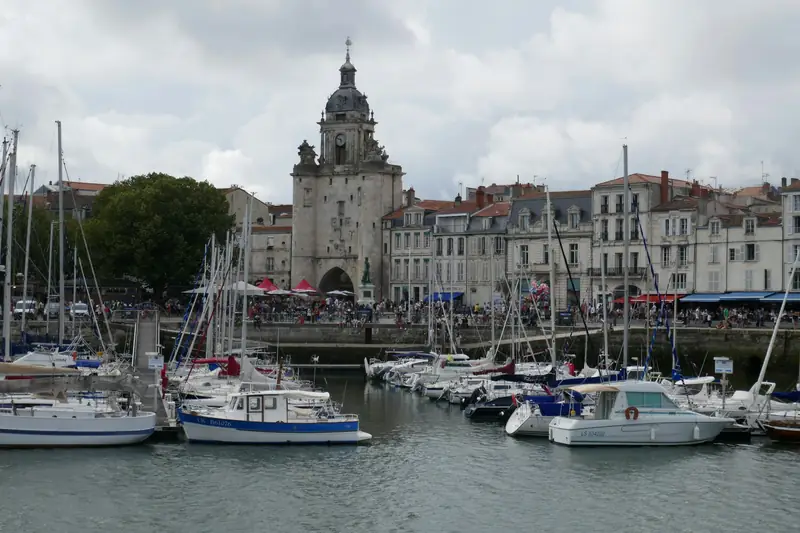 La Grosse Horloge au fond du Vieux-Port, voiliers amarrés au premier plan