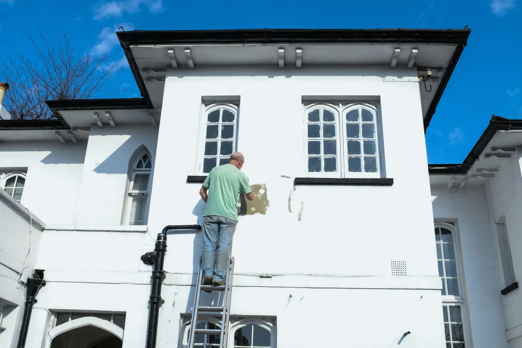 Peintre sur une façade blanche, illustration
