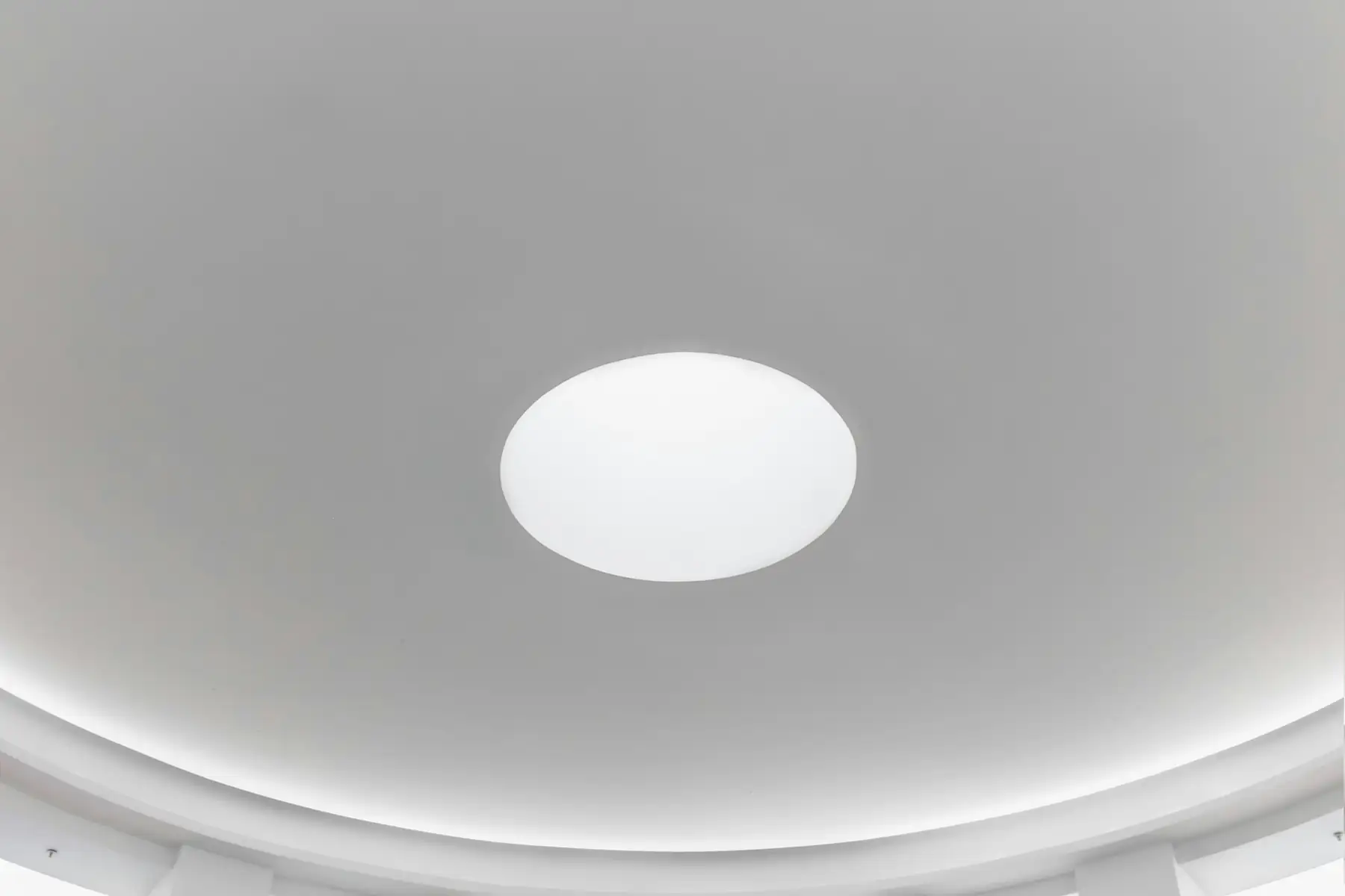 Plafond blanc parfaitement lisse, éclairage rond encastré au centre